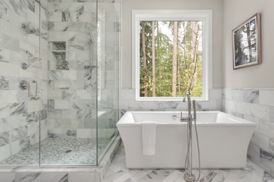 Modern spa-style bathroom with freestanding tub, glass shower, and marble finishes